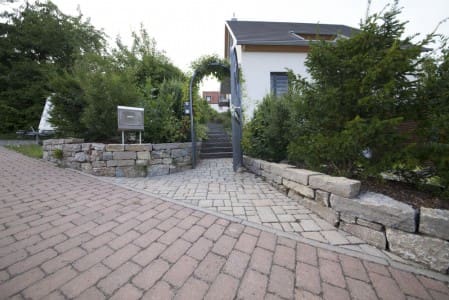 Eingangsbereich mit Naturstein und Rosenbogen